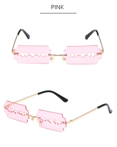 Detail of pink razor blade shaped rimless sunglasses with gold metal frames and cutouts