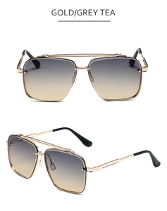 Close-up of gold metal aviator sunglasses with double bridge and grey tea gradient lenses