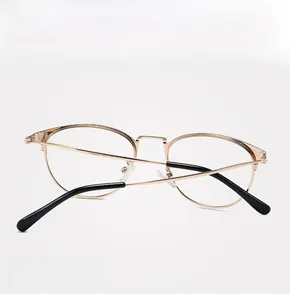 Détail de la monture de lunettes en métal doré brillant avec branches fines pliantes
