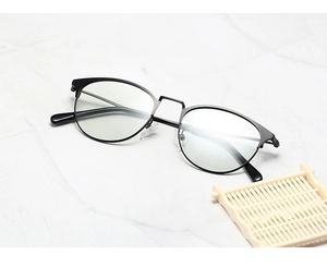 Détail de lunettes anti-lumière bleue à monture noire fine sur fond de marbre