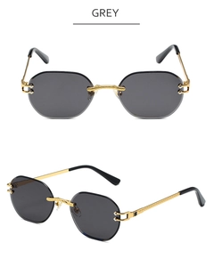 Detail view of grey rimless sunglasses with gold twisted metal bridge and temples