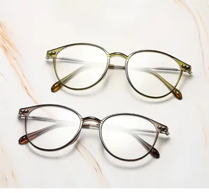 Detail of retro round glasses frames with green and brown resin rims and metal temples