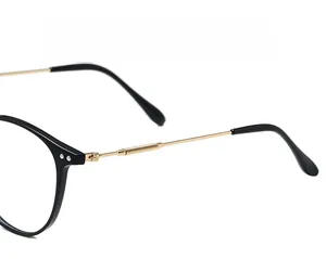 Detail of metal glasses frame showing the elastic spring hinge and gold-toned temples