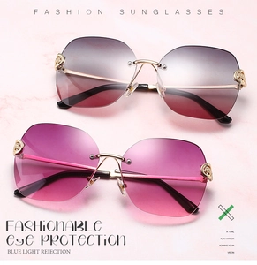 Detail of rimless metal sunglasses with gradient lenses and ornate temple engraving