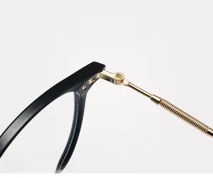 Macro detail of reinforced gold metal hinge and screw on black eyeglass frames