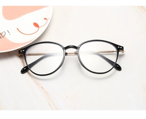 Close-up of black round frames and gold metal textured temples on optical glasses