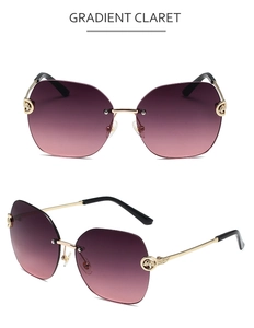 Close-up of frameless gradient claret sunglasses with gold leopard head metal detail