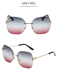 Detail of rimless grey red gradient sunglasses with gold metal panther head hinge accents