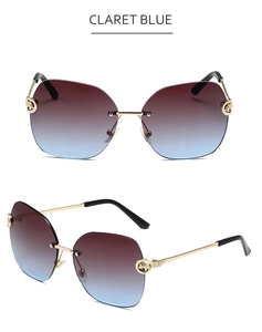 Detail of claret blue rimless sunglasses with gold metal temples and geometric frame