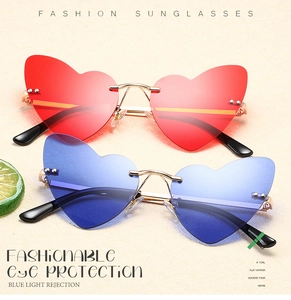 Detail of heart-shaped rimless sunglasses with gold temples and anti-blue light lenses