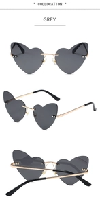 Macro detail of rimless heart-shaped grey sunglasses with gold metal temples and rivets
