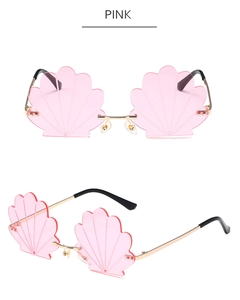 Detail view of pink rimless shell-shaped sunglasses with golden metal bridge and accents