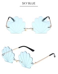 Detail of sky blue rimless shell-shaped sunglasses with golden metal frame and shell texture