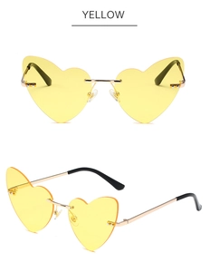 Detail view of yellow heart-shaped rimless sunglasses with gold metal bridge and nose pads