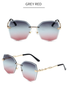Détail de lunettes de soleil sans monture avec verres dégradés gris-rouge et branches dorées