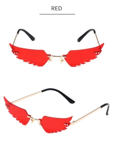 Close-up of red wing-shaped lenses with gold metal frames for hip-hop fashion sunglasses