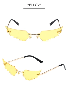 Detailed view of yellow wing-shaped rimless sunglasses with gold metal frame