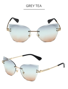 Detail view of rimless cat-eye sunglasses with grey tea gradient lenses and gold frame