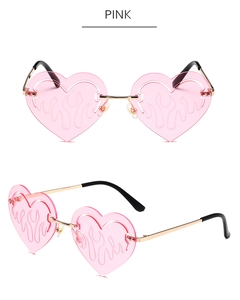 Detail of pink heart-shaped rimless sunglasses with flame engraving and gold temples