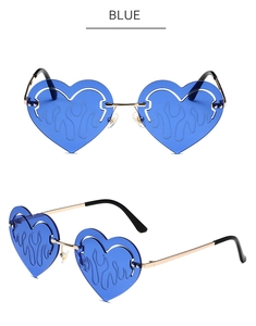 Detail of blue heart-shaped sunglasses featuring flame etched lenses and gold metal frames