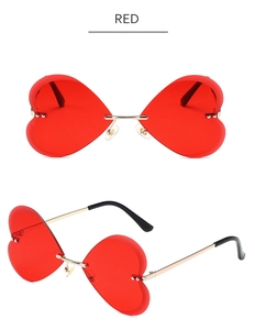 Détail des verres rouges sans monture en forme de cœur avec branches en métal doré