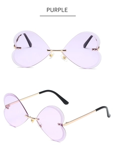 Détail de lunettes de soleil cœur sans monture avec verres violets et monture dorée