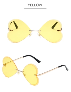 Détail de lunettes de soleil cœur sans monture avec verres jaunes et cadre doré