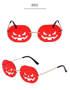 Detail of red pumpkin-shaped Halloween sunglasses with golden metal frames and cut-outs