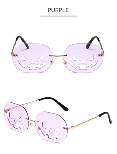 Close-up of rimless purple pumpkin sunglasses with hollow Jack-o'-lantern face lens