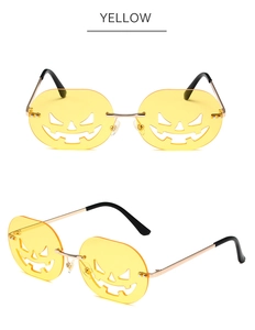 Detail of yellow pumpkin-shaped rimless sunglasses with carved smile and metal temples