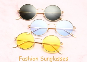 Flat lay of vintage round sunglasses in black, blue, and yellow with gold metal frames