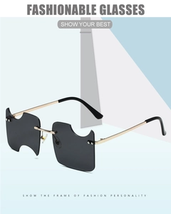 Detailed view of the dark grey notched rimless lens with sleek gold metal temple arms