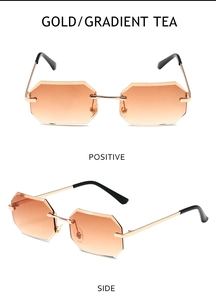 Close-up of rimless octagonal sunglasses with gold metal frame and gradient tea lenses