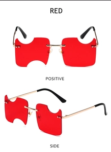 Close-up of red rimless sunglasses with unique notch design and gold metal frames
