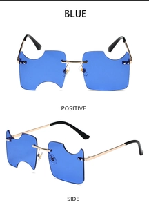 Close-up of blue rimless sunglasses with unique notched edges and gold metal frames