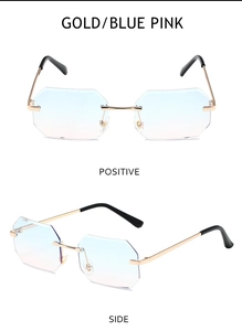 Close-up of rimless octagonal sunglasses with gold metal frame and blue-pink gradient lenses