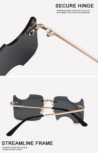 Detail of secure reinforced hinge and streamlined metallic frame of irregular sunglasses