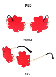 Detail view of red clover-shaped rimless sunglasses with gold metal temples and red lenses