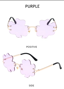 Detail view of purple shamrock rimless sunglasses with gold metal frames and black tips