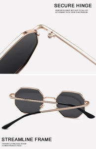 Detail of reinforced metal hinges and octagonal gold frames on stylish sunglasses