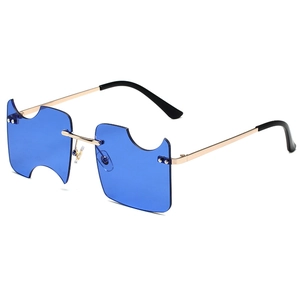 Rimless blue lens sunglasses with geometric cutouts and gold metal frames on white background