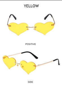 Detail view of heart-shaped rimless sunglasses with yellow lenses and gold metal temples