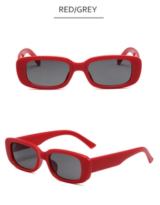 Détail des lunettes de soleil rectangulaires rouges avec verres gris et monture mate