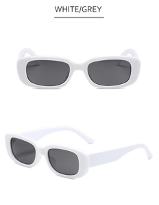 Détail de lunettes de soleil rectangulaires blanches avec verres gris et branches larges