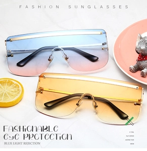 Close-up of oversized rimless fashion sunglasses with gradient blue-pink and orange lenses