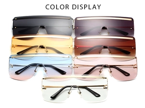 Detailed color display of oversized shield sunglasses with metallic top bar accents
