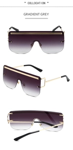 Detail view of oversized sunglasses with gradient grey lenses and gold metal frame