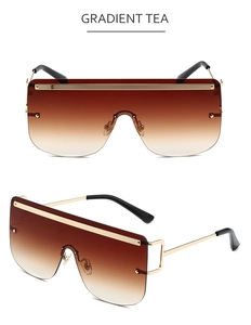 Detailed view of gradient tea lenses and gold metal temples on oversized sunglasses