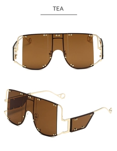 Detail of tea brown oversized shield sunglasses with gold metal frame and rivet accents