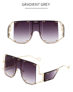 Detail of gradient grey oversized sunglasses with decorative gold studs and metal frame